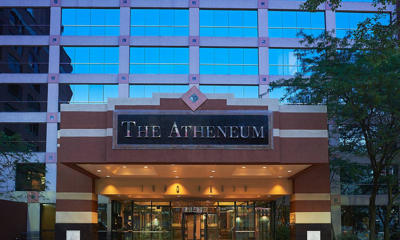 Image of the Atheneum Suite Hotel sign in front of the building
